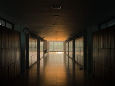 Peaceful school corridor at sunset with lockers and soft lighting.